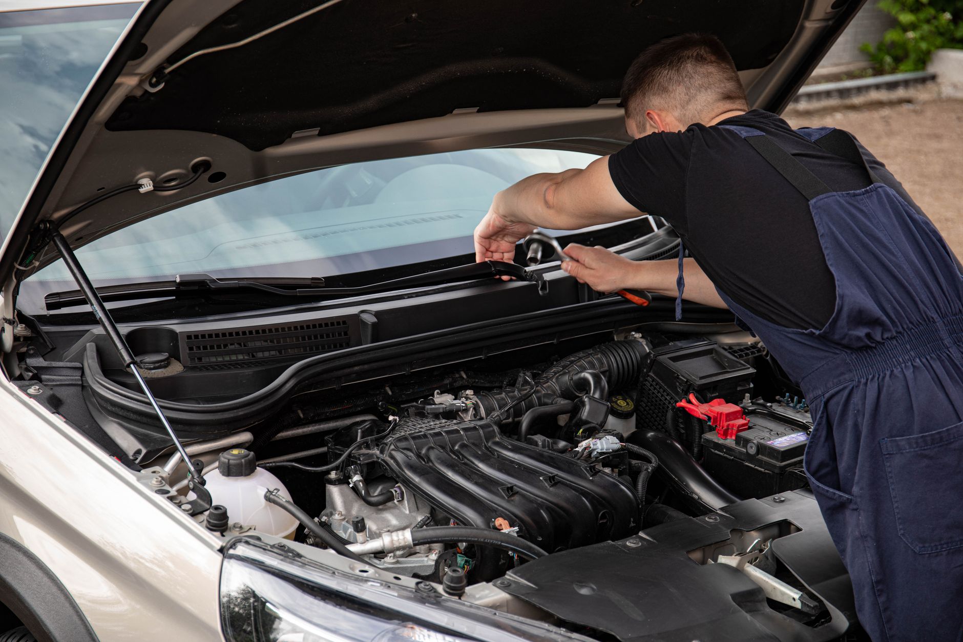 Hyundai i30 z drugiej ręki – na co zwrócić uwagę przed zakupem używanego auta Mechanik naprawia silnik samochodu Hyundai na zewnątrz w dzień