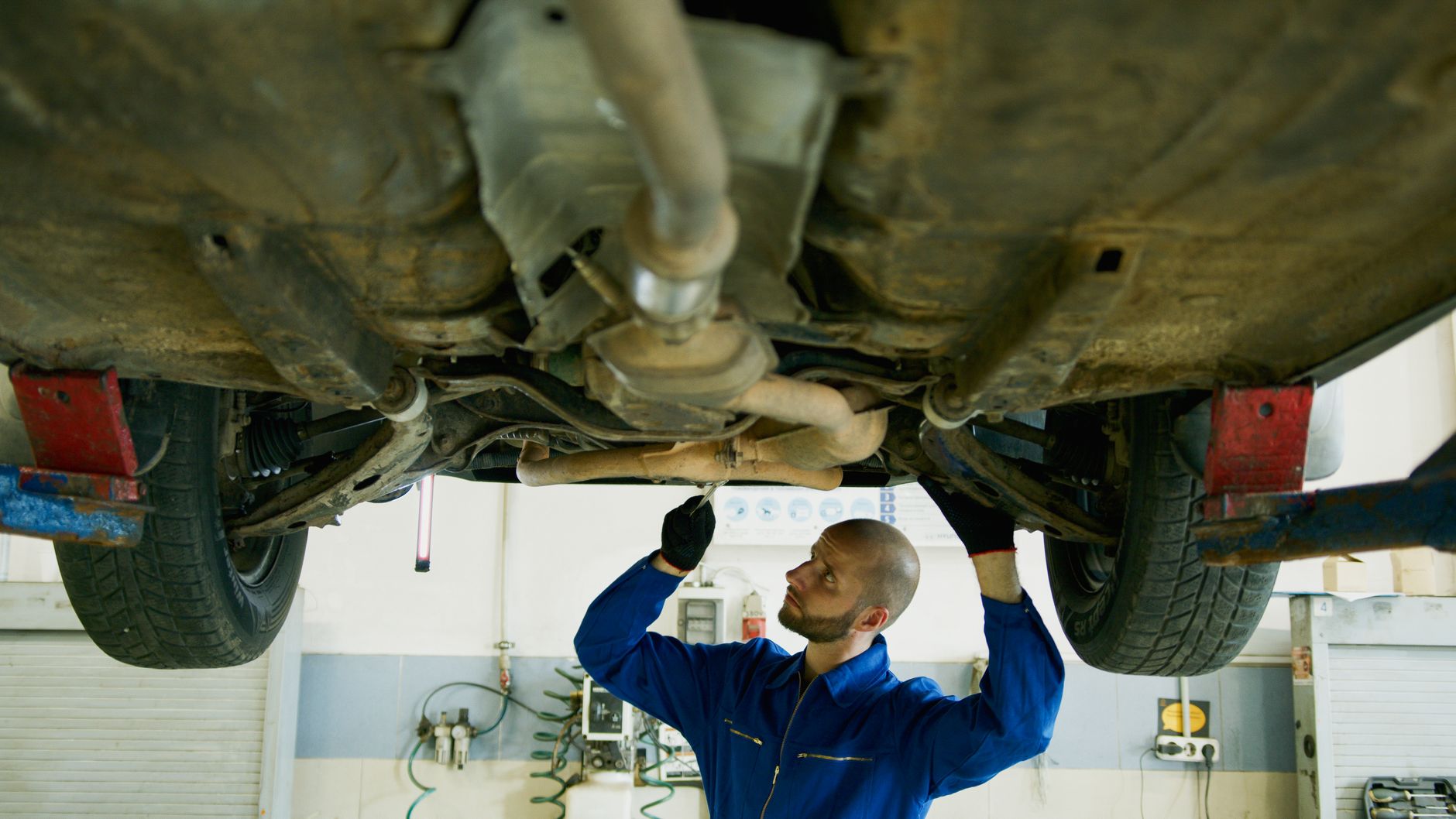 Mechanik sprawdza zawieszenie Suzuki od spodu na podnośniku