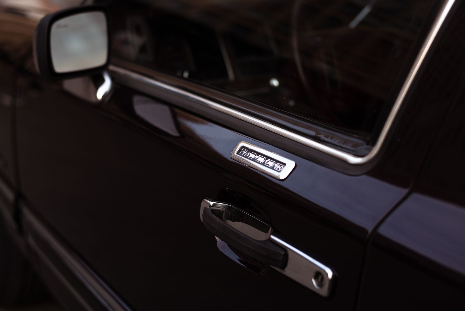 Zbliżenie czarnych drzwi Rolls-Royce z klawiaturą zamka i detalami