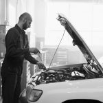Mechanik sprawdzający silnik używanego Peugeota w warsztacie